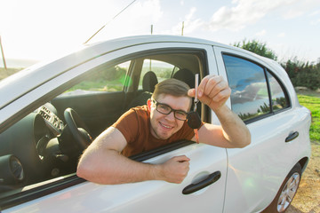 Naklejka premium Happy man showing the key of his new car