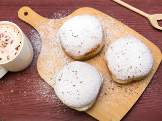 Classic donuts with powdered sugar, on wooden background