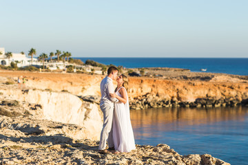 Fototapeta na wymiar Romantic dating. Young loving couple walking together by the beach enjoying sea