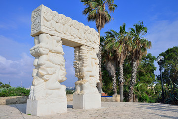 Fototapeta na wymiar Faith stone sculpture on the highest point of Old Yafo on the St. Peter Church background, Tel-Aviv. Israel