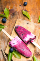 Tasty homemade blueberries ice cream on wooden background. Organic fruit popsicles.
