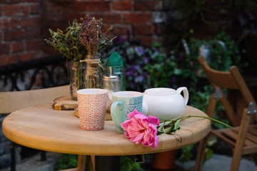 Romantic table in the open air cafe. Two mugs and a flower on the table. Waiting for a date. Natural.