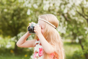 Portrait of a cute girl on photographing beautiful retro camera