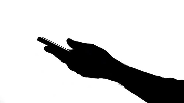 Moving male hand handling a smartphone Side view of a moving black silhouette of a male hand typing and scrolling down on a smartphone, against white background