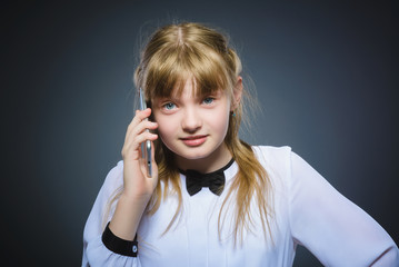 Happy cute girl with cell phone. isolated on gray