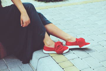 A woman sitting on the street in a blue dress