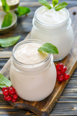 Sour baked milk and natural yoghurt in glass jars.