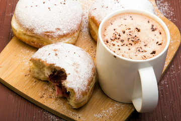Classic donuts with powdered sugar, on wooden background
