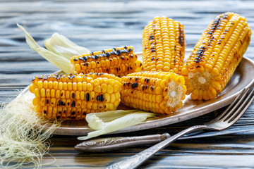 Cobs of sweet corn roasted on the grill. © Saprunova Marina