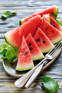 Slices of sweet watermelon, fork and knife on the tray.