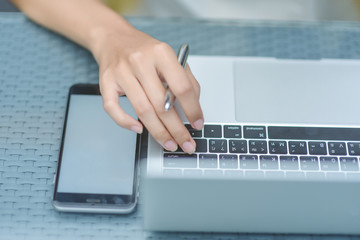 Young pretty business woman with laptop in the office, smiling pretty young business woman in glasses sitting on workplace. Selective focus