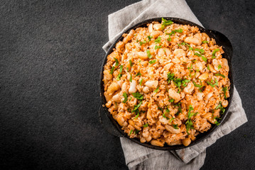 Mexican, Latin American cuisine. Mexican Rice and Beans Bowl is a recipe made with rice and white beans, homemade, with fresh herbs and herbs. In a frying pan for cooking, top view copy space