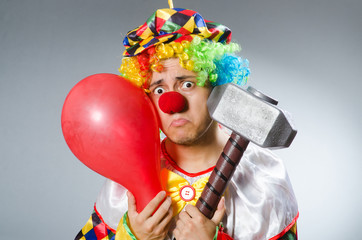 Clown with a hammer grey background isolated