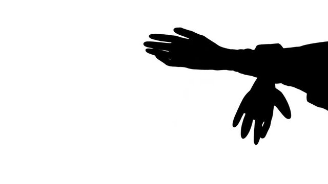 Moving male hands putting on exam/medical gloves Side view of a moving black silhouette of male hands putting on a pair of exam/medical gloves, against white background