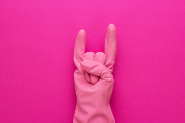 hand in pink protective glove shows horns gesture. cool cleaning service concept