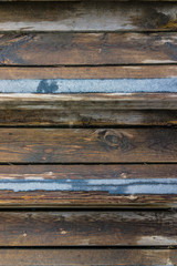 Macro closeup of wet, wooden stairs or steps with blue no-slip strips