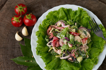 Fresh summer vegetable salad with chicken, fresh lettuce leaves, radish, bell pepper, cucumber, red onion , tomato garlic on old wooden rustic board. Close-up. Top view