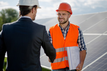 Foreman and businessman concluding a treaty. Agreement between two sides at solar energy station.