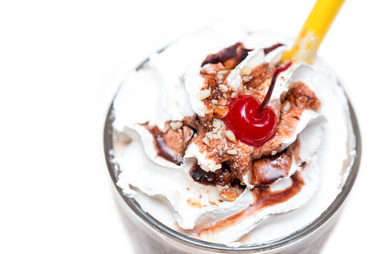 Milk cocktail with chocolate, nuts and cherry on top. Close up image. White background