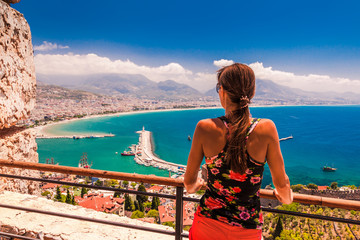 Woman look on landscape of Alanya with marina and Kizil Kule red tower in Antalya district, Turkey,...