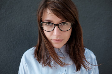 Fototapeta premium Closeup portrait of young attractive woman with glasses on a dark background.