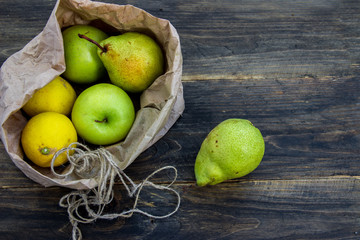 Fresh fruit in a craft bag on a dark background. Concept of healthy eating.