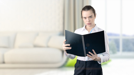 Young beautiful business woman and creative designer standing over blured interior background