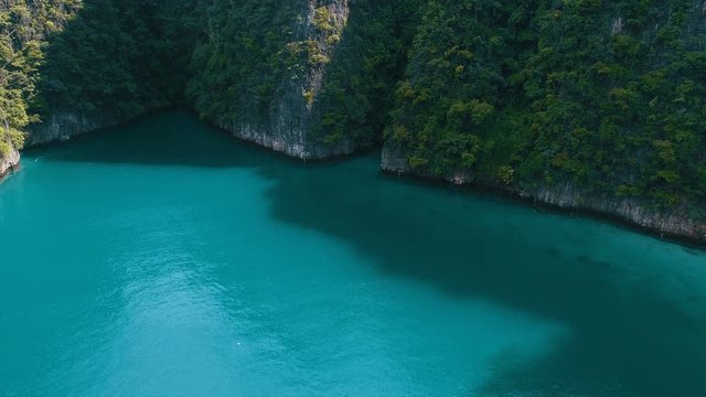Aerial drone view of iconic tropical turquoise water Pileh Lagoon surrounded by limestone cliffs, Phi Phi islands, Thailand