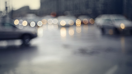 Blurry unfocused background with the city road with cars in twilight