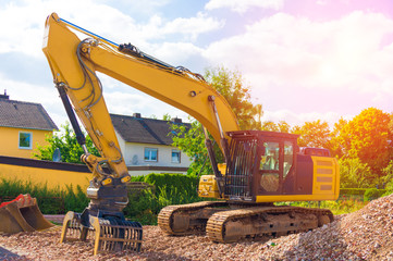 Yellow excavator on the construction site background