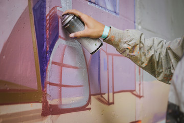 Graffiti artist painting on the wall