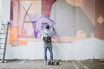 Graffiti artist painting on the wall - 164510797