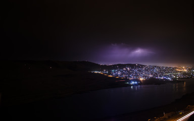 Lightning with dramatic clouds. Night thunder-storm over the mountain and the lake in Baku, Azerbaijan