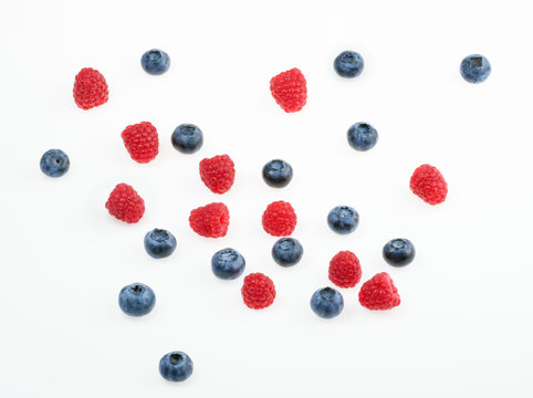 Raspberries and blueberries on white background.  top view
