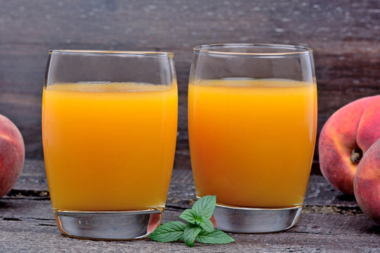 Peach juice in a glasses on wooden background