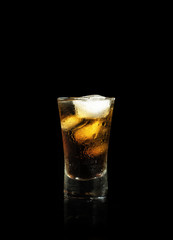 Spirit drink with cola and ice isolated on black