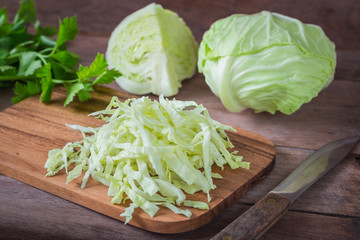 Fresh shredded cabbage on wooden cutting board.