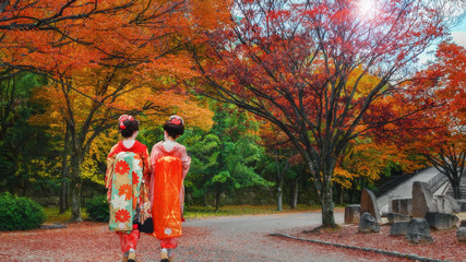 Geisha Girls in a Japanese Garden in Colorful Autumn