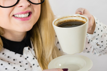 Happy woman at office drinking hot coffee