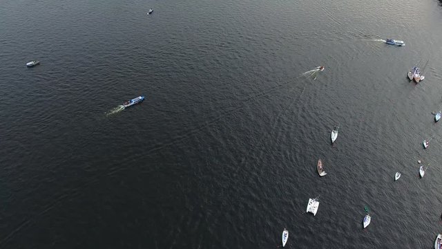 Aerial video of bay with floating sailing yacht fleet in marina during yachting regatta race shot from drone