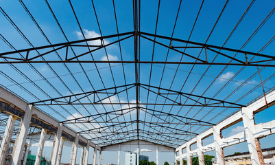 Demolition of an old building with roof only under blue sky