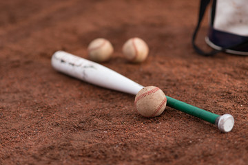 baseball bat and balls and a bag on floor