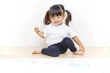 Naklejka premium フローリングで絵を描く幼い女の子