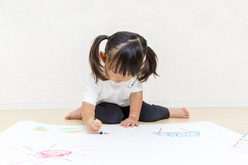 Naklejka premium フローリングで絵を描く幼い女の子