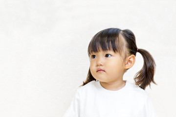 Fototapeta premium 横を見つめる幼い女の子イメージ