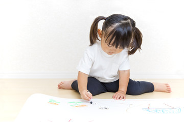 Naklejka premium フローリングで絵を描く幼い女の子