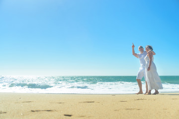 Fototapeta na wymiar Young romantic couple walking on the beach holding hands