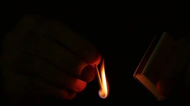 Slow Motion. Man lights a match in darkness. How to Strike a Matchstick. Match heads contain phosphorus, potassium and sulfur, when heated by friction, phosphorus ignites, causing other materials to b