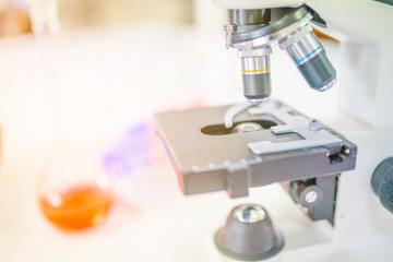 Microscope on the table in laboratory room with laboratory equipment
