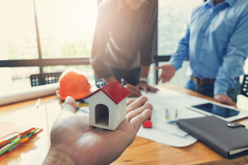 Engineer and Architect concept, Engineer Architects office team working and discussing with blueprints and house model, Vintage Effect